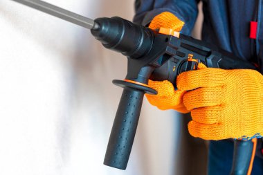  İşçi döner çekiçle yön değiştiriyor. El değiştirme modunda çekiç delme delgisi var. yakın plan