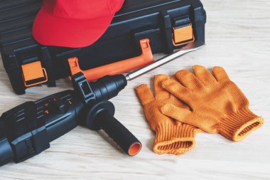 Çalışan aletlerin üst görüntüsü. Döner çekiç, alet çantası, iş kepi, eldivenler. İşçi vitesi konsepti