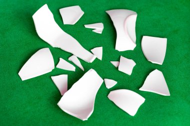 Kırık beyaz kapların kıymıkları ve parçaları. Bir aile kavgasının metaforu. Kırık tabak, cam. Mutfaktaki kaza kavramı. Parçalanmış tabak parçaları.. 