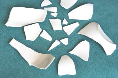 Kırık beyaz kapların kıymıkları ve parçaları. Bir aile kavgasının metaforu. Kırık tabak, cam. Mutfaktaki kaza kavramı. Parçalanmış tabak parçaları.. 