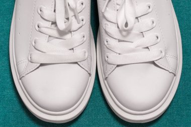 Beyaz spor ayakkabılar, renkli arka plan. Spor ayakkabılar, yaşam tarzı spor ayakkabıları. Şık beyaz ayakkabılar. yakın plan