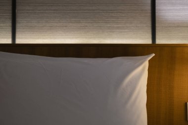 Yatağı ve yastıkları olan, soluk bir atmosferde uyumak ve dinlenmek için yatağı olan modern Japon tarzı yatak başlığı. Kalacak yer, otel..