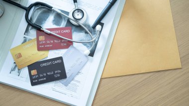 Tıbbi kayıtlar, steteskop ve hastane ödeme sahnesinde elinde altın bir kredi kartı var..
