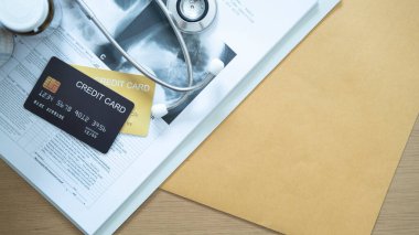 Steteskoplu ve boş zarflı tıbbi kayıtlardaki altın kredi kartı, sağlıkla ilgili finansmanı iletiyor..