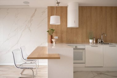 Modern ve minimalist mutfak beyaz mobilyalar, ahşap elementler ve mermer zemin ve duvar