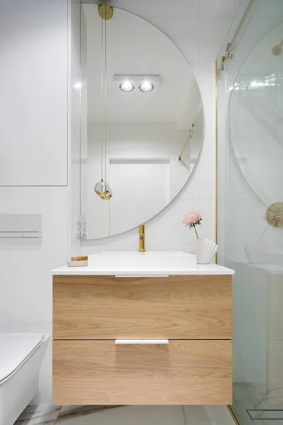 浴室洗脸盆上方有木制抽屉的大半圆形镜子 — 图库照片