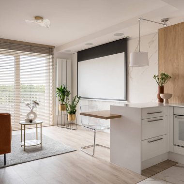 Elegant studio apartment with projector screen on marble wall and living room with big window open to kitchen with white furniture