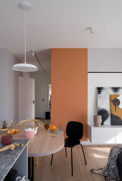 Stijlvolle Eettafel Met Decoraties Modern Eclectisch Appartement Met Oranje Muur Rechtenvrije Stockafbeeldingen