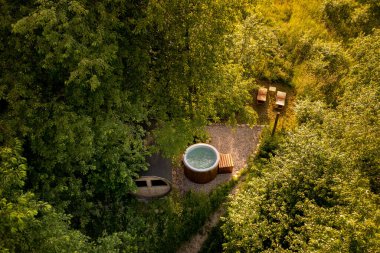 Jakuzinin üst manzarası ve ormandaki kamp alanının rahatlama alanı.