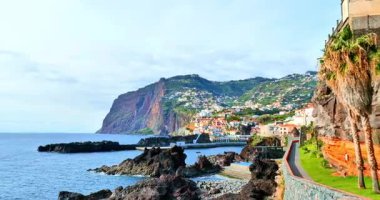 Renkli bir sahil kasabası, sarp yeşil bir yamaçta inşa edilmiş, kayalık oluşumları ve küçük bir limanı olan okyanusa bakan bir tepe. Avuç içi çizgili yürüyüş yolu ve çimenli kayalık tarafı cazibe ve dinginlik ekler.