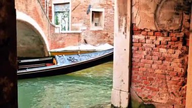 Zarif bir çift Venices 'in gizli kanallarında gondol gezintisi yapıyor. Kırsal tuğla duvarlar, romantik atmosfer ve seyahat, yaşam tarzı, balayı veya sinematik görüntüler için sonsuz cazibe.