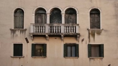Altı pencere, üç kemer yukarıda, üç dikdörtgen aşağıda, yıpranmış Venedik cephesi. Yeşil panjurlar ve balkonu olan küçük bir balkon. Alçı ve lekeler zamanın nasıl geçtiğini gösteriyor.