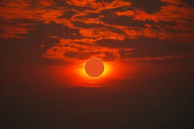 Solar eclipse on clear red orange sky sunset in the evening