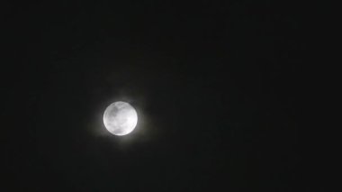 Full Corn Planting Moon shiny on the dark night cloud with cloud passing