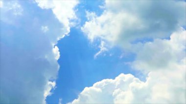 Parlak bir gökyüzünde bulut şeklinde bir bulut oluşumu. Yumuşak beyaz bulutlar, derin mavi gökyüzüne karşı güzel bir tezat oluşturarak, huzurlu ve romantik bir atmosfer yaratırlar..