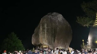 Canlı bir kalabalık, bir gece boyunca büyük bir kaya oluşumunun yakınında toplanır, yıldızların altındaki canlı atmosferin ve güzel çevrenin tadını çıkarırlar..