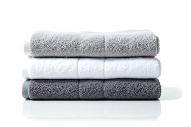 Temiz beyaz bir yüzey üzerinde gri ve beyaz gölgeli yumuşak banyo havlularından oluşan bir derleme. Konfor ve modern minimalist tasarım her banyo için mükemmeldir..