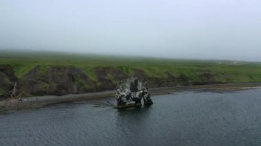 Denizde garip şekilli büyük bir kaya, İzlanda 'nın doğası, sisli hava, insansız hava aracı tarafından vuruldu.