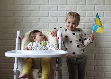 A little girl holds the flag of Ukraine in her hands. Young patriot, blue and yellow flag. A free Ukrainian woman