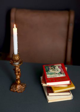 A candle and a book on the table. Bible for reading