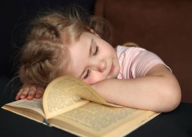 A small child was reading a book and fell asleep on it. Distance Learning
