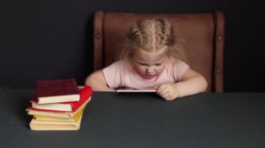 While preparing for school, the child studies at home. Get distracted by your smartphone. Distance learning, homework.