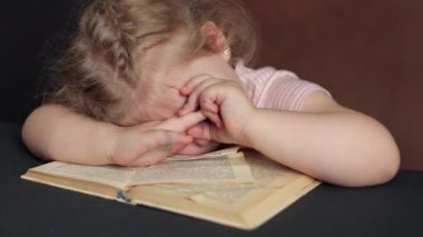 A small child was reading a book and fell asleep on it. Distance Learning