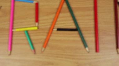 Ahşap bir arka planda renkli kalemler. Okul hazırlığı, resim dersi. Ukrayna kelimesi kalemlerden oluşur..