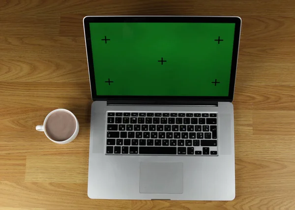 Computer on desktop, green screen. Chromatic key. Laptop for work, green scene.