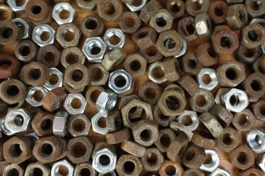 Many rusty elements. Old rusty nut. Dirty metal nuts are scattered on the table. Old spare parts warehouse