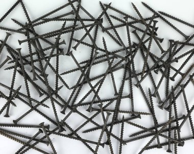 Black self-tapping screws on a white background. Detail for wood. Screw for connecting wood. Lots of screws