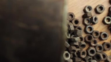 Many rusty elements. Old rusty nut. Dirty metal nuts are scattered on the table. Old spare parts warehouse