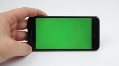 White background, black phone with green screen. Gadget on a white background. Smartphone and color key