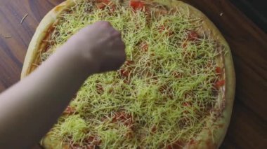 Ton balığı, domates ve peynirli ev yapımı pizza. Düz olmayan pizza hamuru. Evde ahşap bir masada pizza pişirmek. Balıklı sıradan pizza.