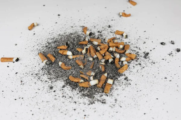 Τσιγάρα Και Στάχτες Πολλά Καπνιστά Τσιγάρα Σκορπισμένα Λευκό Ύφασμα Έντονο — Φωτογραφία Αρχείου