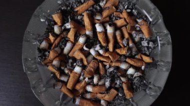 Kül tablasında sigara, kül, bir sürü sigara. Sigara içmek için güçlü bir tutku. Sağlığa zararlı. Sigara içmek sağlığınız için zararlı olabilir. Çevre için çok yazık. Sağlık sorunları.