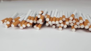 Beyaz arka planda bir sürü sigara. Sigara içmek için güçlü bir tutku. Sağlığa zararlı. Sigara içmek sağlığınız için zararlı olabilir. Çevre için çok yazık. Sağlık sorunu, kansere neden oluyor. Sigara.