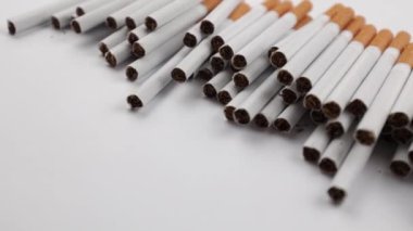 Beyaz arka planda bir sürü sigara. Sigara içmek için güçlü bir tutku. Sağlığa zararlı. Sigara içmek sağlığınız için zararlı olabilir. Çevre için çok yazık. Sağlık sorunu, kansere neden oluyor. Sigara.