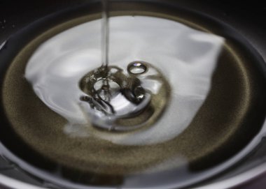 Yağlı boş tava. Yağ tavaya döküldü. Siyah mutfak aletlerine yakın çekim. Kızartma için hazırlık. Kahvaltı hazırlıyorum. Kızartma tavası Black Metal kaplar. Patates kızartması için bolca yağ.