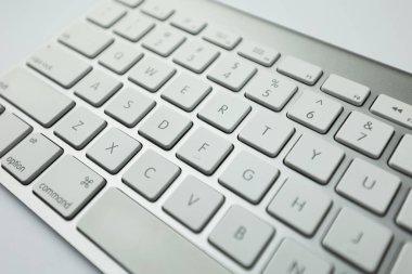 Beyaz düğmeli gri klavye. Kablosuz klavye. Bilgisayar parçaları. Metin giriş aygıtı. Beyaz arkaplanda klavye