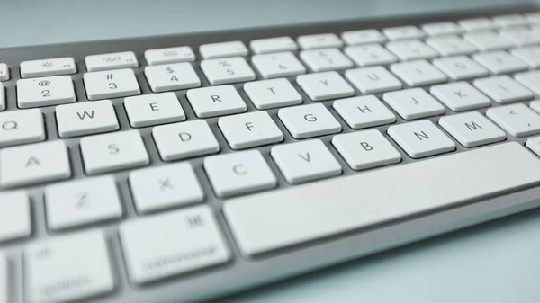 Gray keyboard with white buttons. Wireless keyboard. Computer components. Text input device. Keyboard on a white background