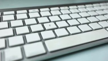 Beyaz düğmeli gri klavye. Kablosuz klavye. Boş düğmelerde harfler ve semboller görünmeye başlıyor. Bilgisayar parçaları. Beyaz arkaplanda klavye