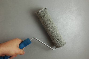 Gri boyayla boyanmış bir duvar. Boya burada işe yarıyor. Daireyi toparlıyorum. Bir silindirle resim yapmak. Yeni boyanmış bir duvar. Binanın tamiri. Çizilen arkaplan