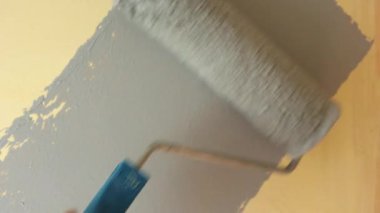 Gri boyayla boyanmış bir duvar. Boya burada işe yarıyor. Daireyi toparlıyorum. Bir silindirle resim yapmak. Yeni boyanmış bir duvar. Binanın tamiri. Çizilen arkaplan