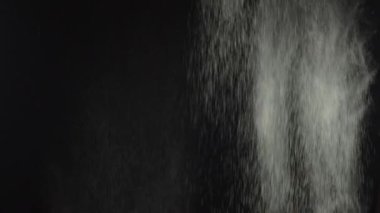 Siyah arka plana un atıyorlar. Beyaz toz patlaması etkisi. Farklı efektler için. Un her yere düşüyor. Siyah arkaplanda beyaz toz