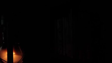 An old kerosene lamp is a light in the dark. There is no electricity.