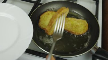 Yumurtada ekmek pişirmek. Tavada yağda kızartma. Beyaz soba, kahvaltı hazırlamak. Siyah kızartma tavası. Tavada çok fazla yağ var. Yağlı yemek, bol kolesterol. Kahvaltıda kızarmış ekmek.