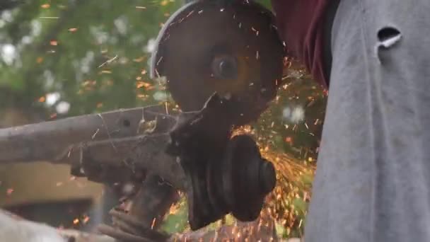 车祸后的汽车修理不受影响 锯开一辆旧车汽车在垃圾场生锈了 被处理掉的废金属 一个人拿着磨床 用圆盘锯铁 — 图库视频影像