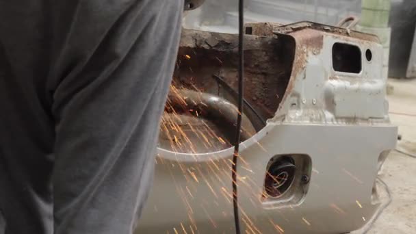 车祸后的汽车修理不受影响 锯开一辆旧车汽车在垃圾场生锈了 被处理掉的废金属 一个人拿着磨床 用圆盘锯铁 — 图库视频影像