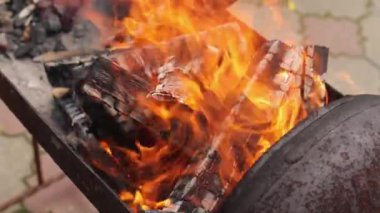 Bahçede barbekü. Yakacak odun, yemek. Barbeküye yakın bir yaz tatili. Ateş yanıyordu. Çevre kirliliği. Yaz pikniği, şenlik ateşi. Brezilya bidonu bir gaz silindirinden yapılır.